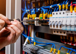 The man is repairing the switchboard voltage with automatic switches. Electrical background